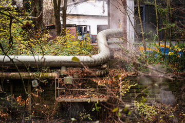 Fernw&auml;rmeleitung vor alten Industriegeb&auml;uden am Ufer der Wupper, Wuppertal, Deutschland