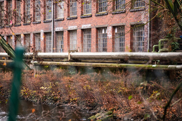 Fernw&auml;rmeleitung vor alten Industriegeb&auml;uden am Ufer der Wupper, Wuppertal, Deutschland