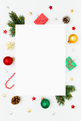 Christmas, New Year vertical frame of fir tree branches, gifts, decorations, balls, candy canes, stars on white flat lay background. Perfect for holiday greetings, banners, social media. Copy space