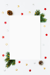 Christmas, New Year vertical frame of fir tree branches, pinecones, decorations on white flat lay background. Perfect for holiday greetings, banners, social media. Copy space