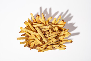 A overhead shot of a pile of french fries on a white background.  