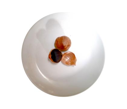 Top view of garlic single clove heated for two weeks until it turns black (Herbal medicine) isolated on transparent background.