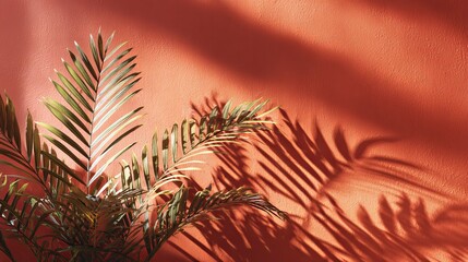 Vibrant terracotta wall bathed in warm sunlight casting dramatic palm leaf shadows for tropical ambiance
