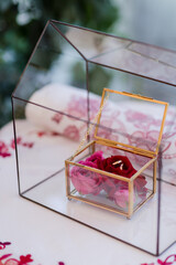 Modern wedding jewelry. Closeup of two wedding rings in a vintage box with flower petals.