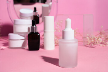 Cosmetic cream containers on pink