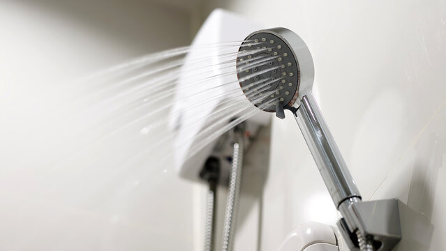 Modern showerhead with water spraying in a bathroom setting, showcasing sleek design and functionality, ideal for home improvement and renovation projects