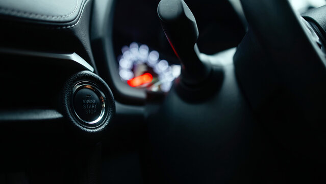 Close-up view of a modern car's ignition button and gear shift, showcasing sleek interior design elements and advanced technology features in an automotive environment