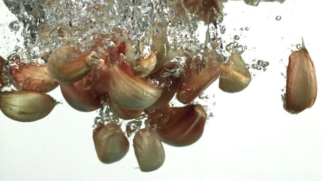 Garlic cloves fall under water. Filmed on a high-speed camera at 1000 fps. High quality FullHD footage