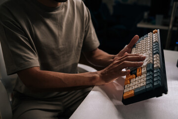 Person carefully cleaning mechanical keyboard with antibacterial wipe, ensuring good hygiene and maintenance for home office computer equipment, preventing germs and dust buildup.