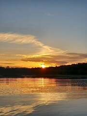 Obraz premium A beautiful golden sunset reflecting off of Canada Lake in the Adirondack Wilderness.