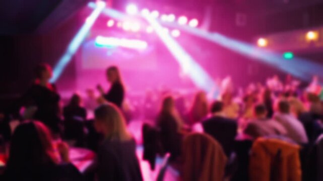 Upscale gala with guests at candlelit tables watching captivating live act under colorful lighting