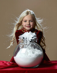 A young child having fun throwing snow onto a snow globe
