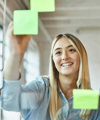Businesswoman meeting at office and use post it notes to share idea. Brainstorming concept. Sticky note on glass wall.
