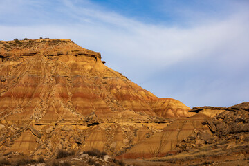 Fototapeta premium Vibrant layers of earth rise majestically under a clear blue sky in the arid landscape