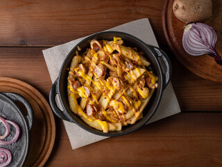 Baked potatoes with homemade sausages in cheese sauce, photo for restaurant menu