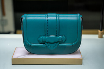 Elegant Teal Leather Handbag Displayed on Pedestal