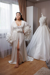 Model poses elegantly in a bridal setting with a stunning wedding dress nearby