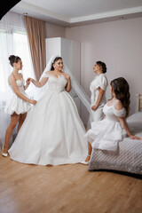 Fototapeta premium Bridal preparation with bridesmaids in elegant gowns at a cozy indoor space