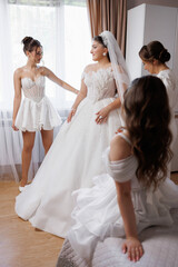 Naklejka premium Bridesmaids helping the bride prepare for her wedding day in a bright room