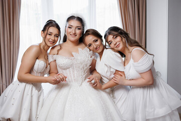 Bridal party celebrating together in elegant white attire before the wedding ceremony