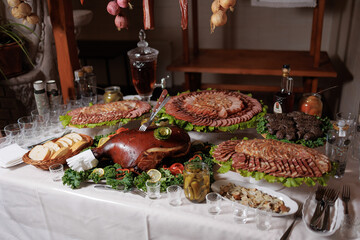 Feast of assorted meats, breads, and sides displayed on a table for celebration