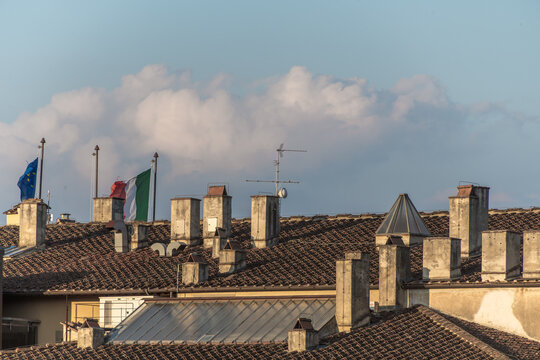 Schornsteine mit Flaggen vor Wolkenhimmel