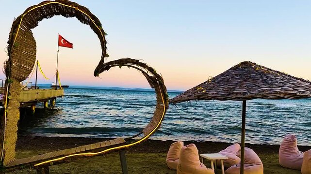 A romantic sunset view on the Şark&ouml;y coast, adorned with a Turkish flag and a heart-shaped arch.