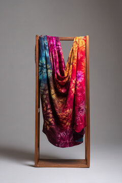 A traditional "adire" (tie-dye fabric), with vibrant indigo patterns, draped elegantly on a simple wooden display stand.