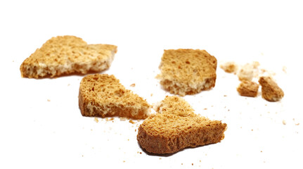 Broken rusks with wholewheat flour, pieces whole wheat dry bread with crumbs isolated on white background, side view