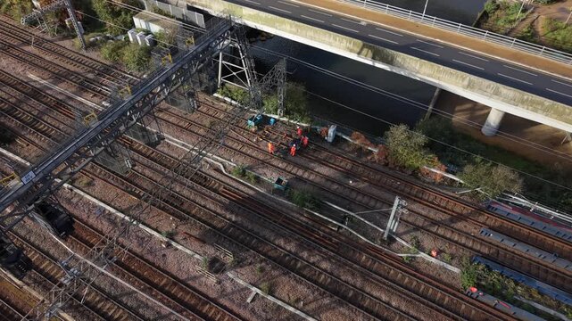 Aerial View of Workers on Railway Tracks Near a Bridge