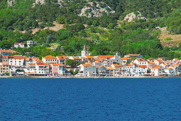 Fototapeta premium Scenic coastal town with red roofs and church by the sea. Baška, Krk island, Croatia