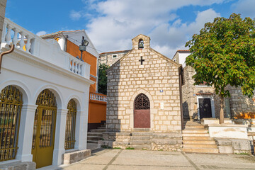 Charming mediterranean stone buildings in historic village square under blue sky. Omišalj, Krk...