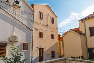 Charming mediterranean architecture in sunlit alleyway. Omišalj, Krk island, Croatia