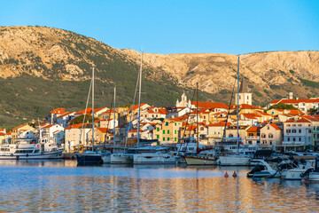 Scenic coastal view of a mediterranean town with boats and hills. Ba&scaron;ka, Krk island, Croatia