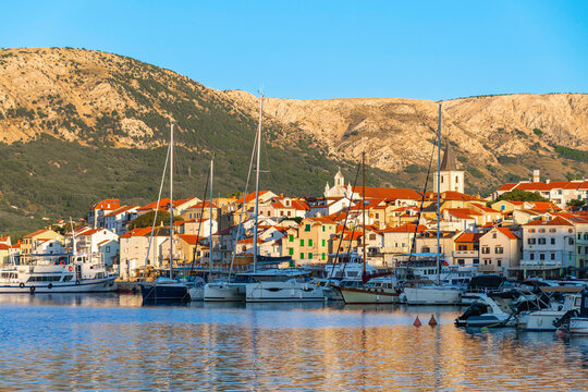 Scenic coastal view of a mediterranean town with boats and hills. Ba&scaron;ka, Krk island, Croatia