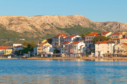 Charming coastal town with mediterranean architecture along serene waterfront. Baška, Krk island, Croatia