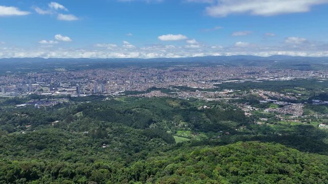 Imagem da cidade de Mogi das Cruzes SP vista do Pico do Urubu, destacando o contraste entre a densa &aacute;rea urbana e a vegeta&ccedil;&atilde;o preservada das montanhas do Alto Tiet&ecirc; paulista