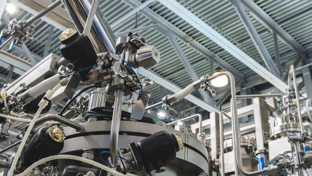 Medical pharma production machine with many tubes and other devices in pharmaceutical factory, pharmaceutical medical production concept background.