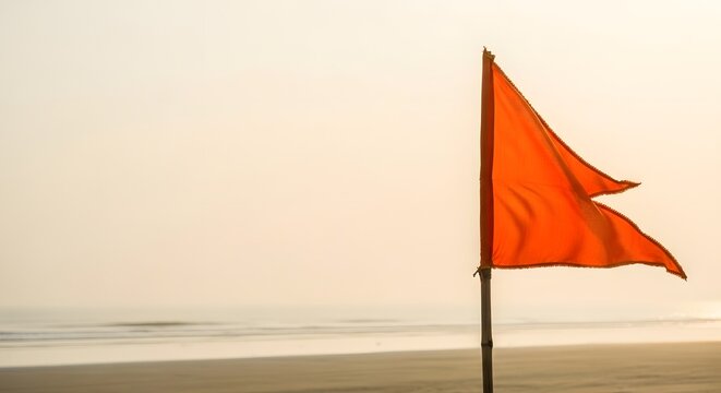 Saffron flag flying on a pole at Ganga Sagar Mela beach during sunrise for spiritual pilgrimage concept and Hindu devotion