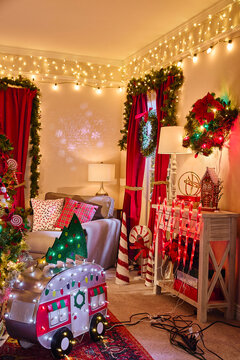 Festive living room decorated with red curtains, string lights, wreaths and holiday themed ornaments