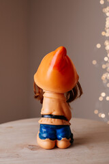 Retro dwarf toy rear view on wooden table with soft bokeh lights