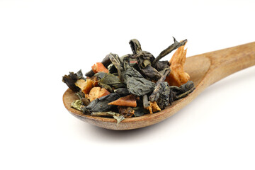 A pile of dry green tea on a white background. Apple flavor. Top view, isolated, close-up. Extreme close-up on the spoon.