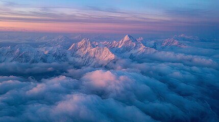 Majestic mountain peaks emerging through clouds at sunset over horizon  