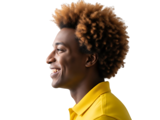 Close up profile of a young black man with curly blonde hair smiling and wearing a yellow shirt against a black background