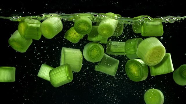 Sliced leeks fall under water. Filmed on a high-speed camera at 1000 fps. High quality FullHD footage
