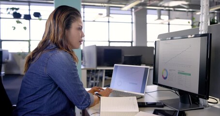 After spotting upward charts woman in blue shirt analyzing data on laptop in office, copy space - Powered by Adobe