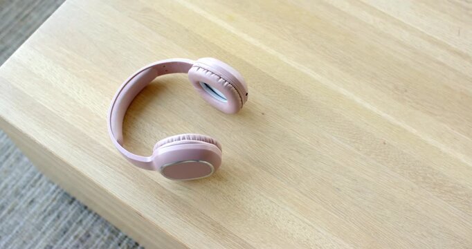 Camera is starting recording capturing overhead shot of pink wireless headset on table for display