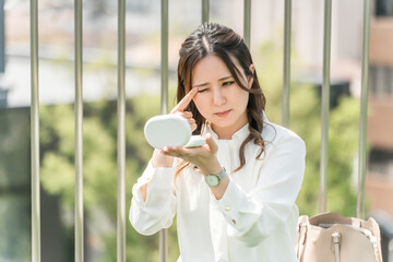 A woman touching up her makeup during a break (eyeshadow, eye makeup, eyeliner, stye)
