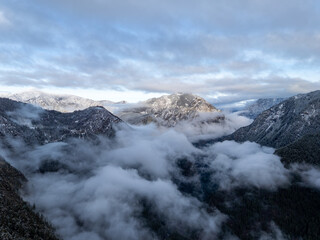 Snowy Mountain Peaks Shrouded in Clouds Over a Valley in British Columbia, Canada