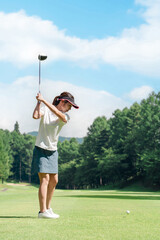 Female golfer playing golf on a golf course (tee shot, golf competition)
